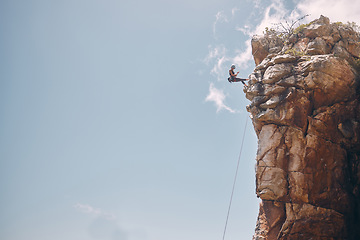 Image showing Mockup blue sky, mountain climbing woman and rock wall fearless hiking on abseiling training rope outdoor. Healthy fitness risk, adventure freedom challenge and strong surreal nature for sports cliff