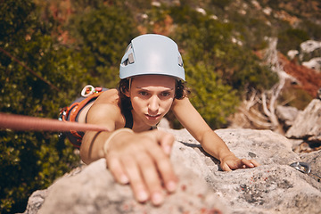 Image showing Sports, exercise and mountain climbing with a woman climber scaling or abseiling a cliff. Fitness, workout and training with a young female on a climb in the forest or woods in nature from above