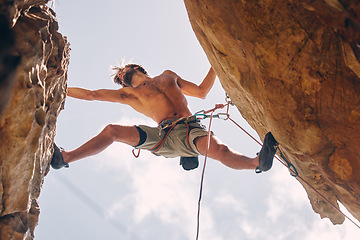 Image showing Fitness, rock climbing and strong mountain climber on a cliff with ropes in summer challenge and extreme exercise. Danger, courage and healthy man fearless, sports and big rocks or stone below view