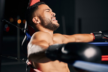 Image showing Boxing, pain and tired boxer in the ring fighting in a sports arena or stadium for a competitive championship. Fitness, exercise and intense training workout by a young Latino fighter with an injury