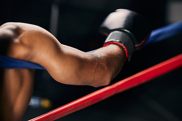 Image showing Sports, fight and hand of a boxing man resting in the corner of a boxing ring during an exhibition match, exercise or workout. Motivation, fitness and training boxer relax and tired after fighting