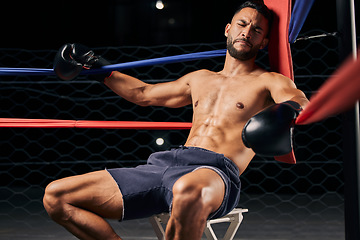 Image showing Sports, defeat and boxer tired in a boxing ring after fighting competition, fitness or training workout. Boxing man in pain, fatigue and sad or hurt after exercise or gym exhibition match failure