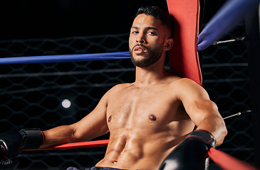 Image showing Boxing, sport and workout with a male boxer in the ring for a fight, match or training. Health, fitness and exercise with a strong sports man resting between rounds of a fighting competition