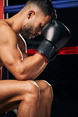 Image showing Boxing gloves, boxer sports man in fight match or prepare for tournament Fitness, training and strong or powerful young prizefighter sitting in a ring thinking of technique, motivation or challenge