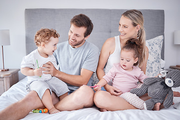 Image showing Family, morning love and happiness with children and parents sitting on the bed and playing at home. Bond, playful and bedroom fun with a man and woman spending free time with their toddler kids