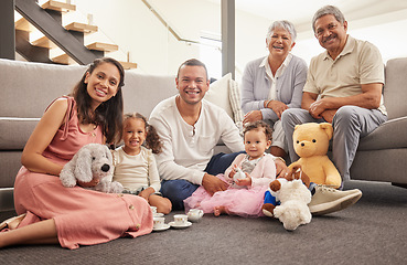 Image showing Portrait of a happy family having a tea party in a living room together, smiling and relaxing on a floor. Cheerful grandparents enjoying the weekend with their grandkid, being playful and having fun