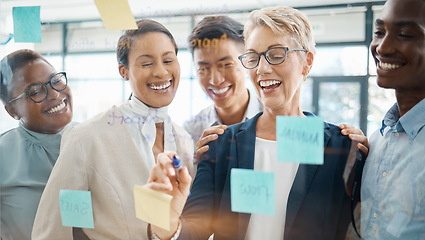 Image showing Teamwork, planning and strategy with a business woman, manager or CEO working with a team on a glass wall and sticky notes. Collaboration, learning or development with a group in an office for growth