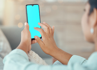 Image showing Woman with green screen phone in hand, for mockup or marketing on living room sofa in home. Lady typing on smartphone with copy space for advertising for app developer or ecommerce company logo