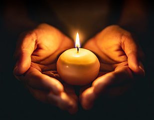 Image showing small candle burning held in hands on black background generativ