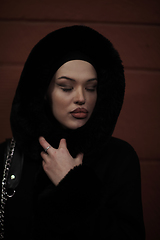 Image showing Muslim woman walking on urban city street on a cold winter night wearing hijab