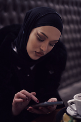 Image showing Muslim woman walking on an urban city street on a cold winter night wearing hijab