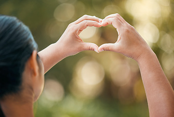 Image showing Woman use hands, make heart or love sign outside with bokeh in nature background. Lady with fingers together, show icon or expression of romance against outdoor backdrop with blurred natural light