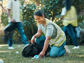 Image showing Volunteer, recycle pollution cleaning charity group working together to collect trash for sustainability. Community support, sustainable and eco friendly people help to clean park grass outdoor