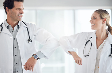 Image showing Elbow greeting, covid or hospital doctors in compliance to stop global virus spread in healthcare or wellness room. Smile, happy or collaboration in man or woman medical teamwork in social distancing