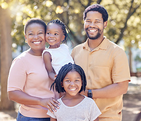 Image showing Portrait of a happy black family in nature in a garden for summer picnic while on holiday. Smile, love and african mother and father with their girl children in outdoor park on a countryside vacation