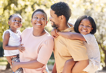 Image showing Black family, nature and parents carrying children, bonding and spending free time on a sunny day. Support, love and happy caring man and woman on a walk at a park with their cute girls outside.