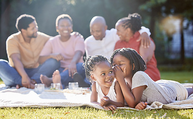 Image showing Secret, sister and children with a girl whispering to her sibling and a black family in the background. Kids, mystery and gossip with a female child being secretive on a picnic in the park in summer