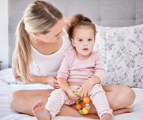 Image showing Portrait of girl with mother in bedroom in home, bonding and playing while holding toy. Love, family and caring happy woman with little kid, child or toddler spending free time together in the house
