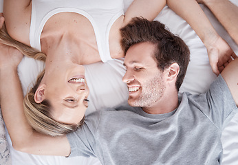 Image showing White happy couple above, smile and bed relaxing together in happiness for relationship, bonding and care at home. Man and woman smiling in love, lying and relax for bedroom time and break in comfort