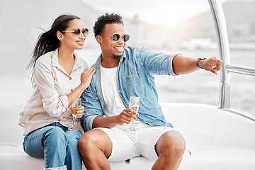 Image showing Happy couple on a luxury boat with a glass of champagne while on the ocean or sea during summer. Young man and woman drinking wine while sailing on a yacht or cruise on expensive vacation.