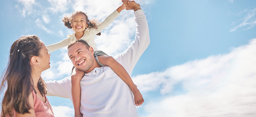 Image showing Family, children and love with foster parents and adopted girl outside during day with a blue sky in the background. Mother, father and daughter spending time together and bonding with love and care