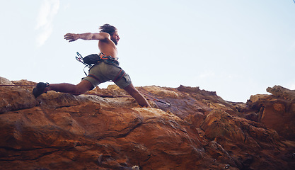 Image showing Mountain, sport and climbing with a sports man running along a rocky surface for health, fitness and exercise. Workout, training and cardio with a young male climber athlete in the mountains
