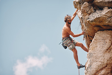 Image showing Man mountain or rock climbing while cliff hanging and adrenaline athlete on adventure and check safety equipment, hook and rope. Fearless man doing fitness, exercise and workout during extreme sport