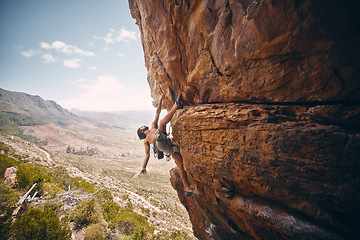 Image showing Rock climbing, rope and fearless mountain climber on a cliff, big rocks and risky challenge alone in summer. Mountaineering, bouldering and strong man training his body for balance outdoors in nature