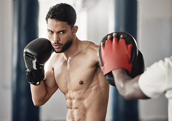 Image showing Fitness, training and a man boxing in gym with personal trainer and sparring pads. Health, motivation and exercise, boxer throwing a punch. Fight, muscle and workout with sports gloves in mma studio.