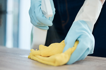 Image showing Woman hand cleaning with spray on a table or furniture surface with a cloth in the living room. Busy cleaner or maid with routine housework and chores for a neat, hygiene and germ free living space