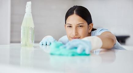 Image showing Kitchen, product and cleaner cleaning a table with dirt or dust with detergent, cloth and gloves. Woman maid, domestic employee or housewife doing housekeeping in a modern office or house.