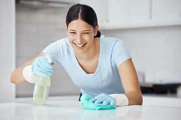 Image showing Happy woman cleaning home kitchen, spray product cleaner with safety gloves and polish table with cloth. Domestic happiness, young girl disinfect counter with sanitary detergent and tidy apartment
