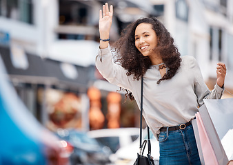 Image showing Urban woman, calling taxi and retail bags after positive shopping trip in a busy city. Young girl in the street with store purchase packages while looking for transport service in town.