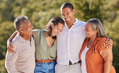 Image showing Happy, hug and smile, an adult family in a park standing together. Mother, father grown up kids laughing. Happiness, love and nature, man and woman with senior couple in nature at an outdoor event.