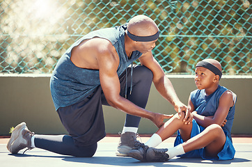 Image showing Basketball knee injury kid with dad put emergency band aid for sports training game accident at basketball court. African black father and injured child team with healing leg pain and wound plaster