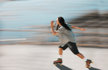 Image showing Fitness, exercise and a man on roller skates moving fast with blurred background. Action, movement and an adrenaline rush skating in road. Speed, sports and a dreadlocks skater having fun in the sun.