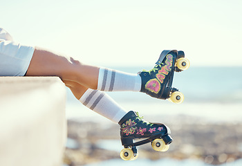 Image showing Relax roller skate woman legs at beach, ocean harbor or sea water with holiday fun, freedom and adventure travel. Feet of sports athlete or skater girl with skating shoes for summer outdoor journey