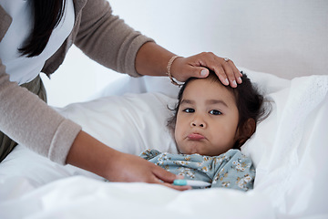 Image showing Sick baby in bed with mother hands for child care, support and love. Sad girl at home in winter with a fever, cold or flu and parent, mom or woman help and check temperature with hand on forehead