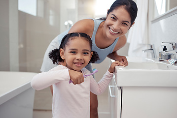 Image showing Mother with child learning to brush her teeth in a bathroom for morning dental, oral and wellness routine. Mom with girl kid with toothbrush in a portrait for dentistry, support and mouth healthcare