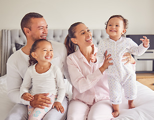 Image showing Happy family, love and morning bonding with parents, child and baby playing in the bedroom and having fun together at home. Loving man and woman spending time with their playful kids to relax