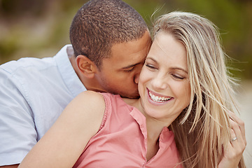 Image showing Happy interracial couple, love and smile for relationship together in nature happiness and outdoors. Man and woman smiling in joyful marriage, neck kiss and bonding time outside on holiday vacation