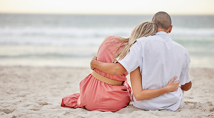 Image showing Happy, love and couple on a beach hug watching the sunset, beach waves and sea together. Happy boyfriend and girlfriend embracing on the sand by ocean water in nature on a summer travel vacation