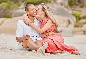 Image showing Kiss, love and couple on beach sand with happy smile for holiday or vacation together. Healthy happiness and interracial man and woman or people relax on ground for wellness lifestyle