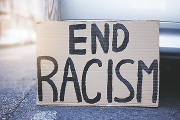 Image showing End racism placard, sign and poster for protest in an urban street background for equality, human rights and race problem. Cardboard or billboard advertising fairness, justice and community freedom