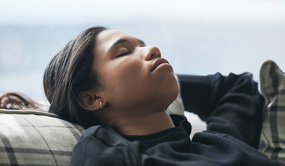 Image showing Relax, tired and rest with woman on sofa in living room for stress management, mental health and fatigue. Exhausted, sleeping and peace with young female lying on couch for calm, relaxation and nap