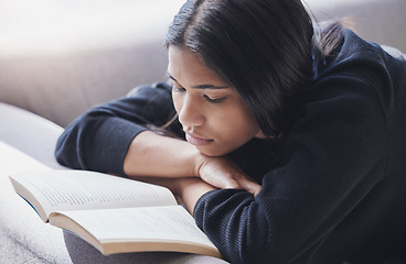 Image showing Reading, book and serious woman on sofa learning and enjoying hobby, relax and free time at home. Mindful female with novel for knowledge, study and literature or fiction story