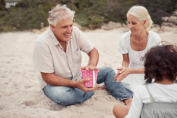 Image showing Happy, sand and grandparents playing with their grandchildren at the beach during summer. Positive elderly man and woman building sandcastle with their grandkids by the ocean while on family vacation