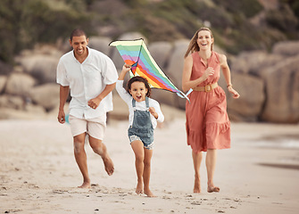 Image showing Happy family with child and a kite on the beach in summer for wellness, growth and energy while running together on sand. Love, care and healthy support of mother, father and girl at outdoor holiday