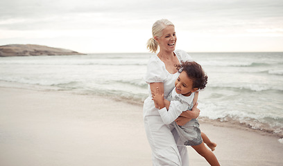 Image showing Beach, fun and grandmother playing with child for holiday, bonding and care together by the ocean. Summer, vacation and happy relationship with young foster girl and grandma embracing by the sea