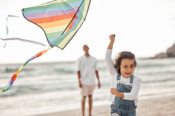 Image showing Family, beach and kite with child running for summer holiday, happiness and childhood while father watches. Happy, youth and childhood with young girl playing with colorful toy at seaside vacation